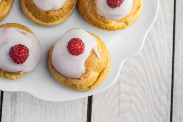 Detailed Top View on Raspberries Profiterole with White Chocolate on Plate stock photo