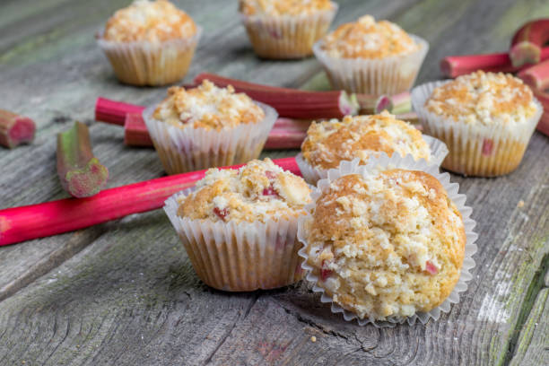 Rhubarb muffin with rhubarb petioles in the background stock photo