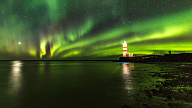 The Gardur lighthouse under the light of the aurora borealis stock photo