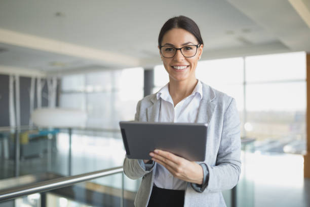 istock Young businesswoman using digital tablet in office building hallway. 650742252