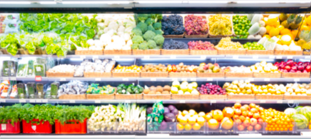 Fresh fruits and vegetables on shelf in supermarket. Blur