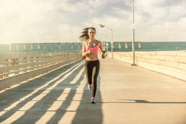 istock Young Women Runner On Ocean Beach Pier 650770368