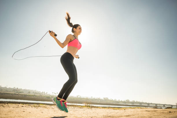 A young Mexican women stretching jump roping by the San Diego river.