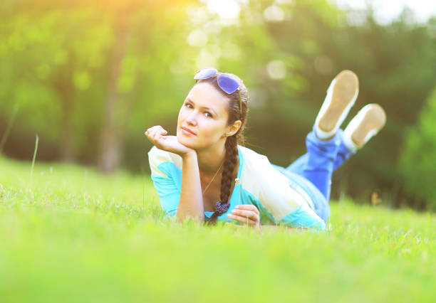 istock Young pretty woman lying on the grass at summer sunset 650778014