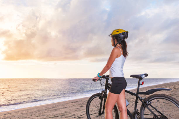 istock Young woman with bicycle at the beach 650791356