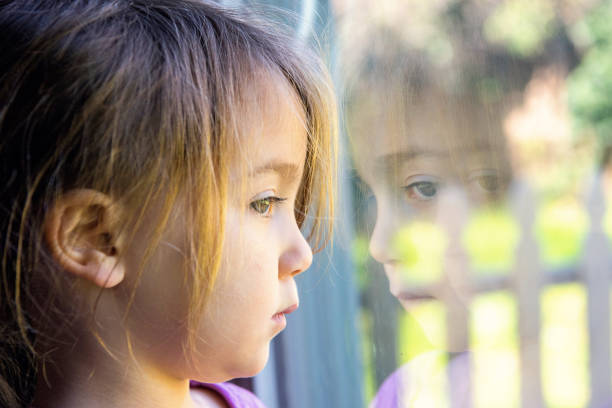 istock Serious girl looking through a window 650807210