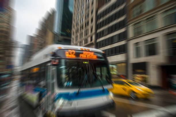 Passenger bus and yellow taxi moving in Manhattan, New York Passenger bus and yellow taxi moving in Manhattan, New York City. There is zoom in zoom out photo effect in the photo. Horizontal composition. Image taken with Nikon D800 and developed from Raw format. There are one bus and one yellow taxi in the photo. city zoom out stock pictures, royalty-free photos & images