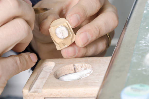 istock Dental technician putting a ceramic tooth in a dental cast model. 650841572