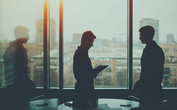 istock Silhouette of two businessmen in office interior 650856104