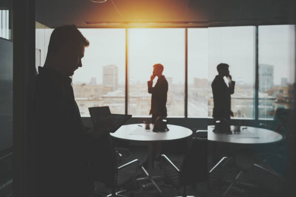 istock Silhouette of two businessmen in office interior 650858550