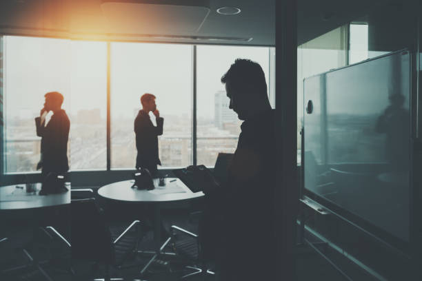 istock Silhouette of two businessmen in office interior 650859204