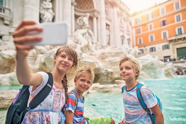 Kids tourists making selfie at Trevi Fountain, Rome Kids visiting Rome, Italy. They are taking selfies in front of Trevi Fountain. The girl is aged 10 and her brothers are aged 7.
 city break photos stock pictures, royalty-free photos & images
