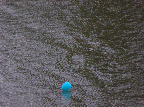 a balloon that got away floating away, alone, down the river.