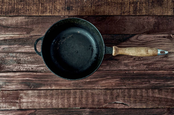 istock Black cast-iron frying pan on a brown wooden surface 650925272