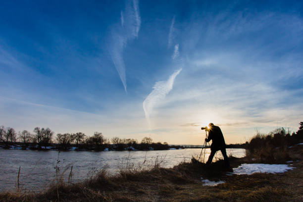 istock Professional photographer taking a photo flooding river at sunset 650929284