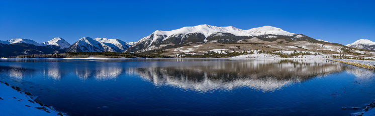 Mount Elbert Sawatch Mountains Reflections in Lake - Panoramic view of scenic mountain landscape in winter on sunny day.