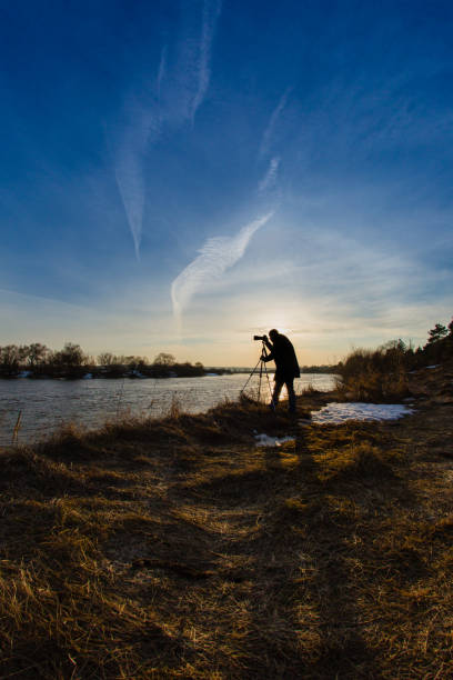 istock Professional photographer taking a photo flooding river at sunset 650940940
