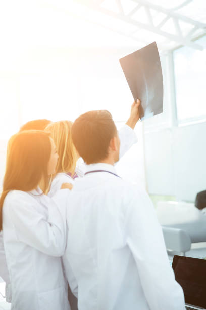 istock group of doctors surgeons looking at x-ray after surgery 650977914