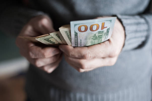 istock Close-up of a man hands counting dollar notes 650983194
