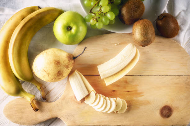 istock Ingredients for fruit salad. Cutting banana 651010248