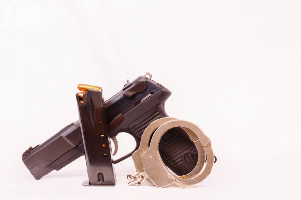 istock Pistol, clip and handcuffs with a white background. 651011154