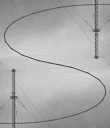 Circular antenna arrays join together.  Composite image, monochrome.