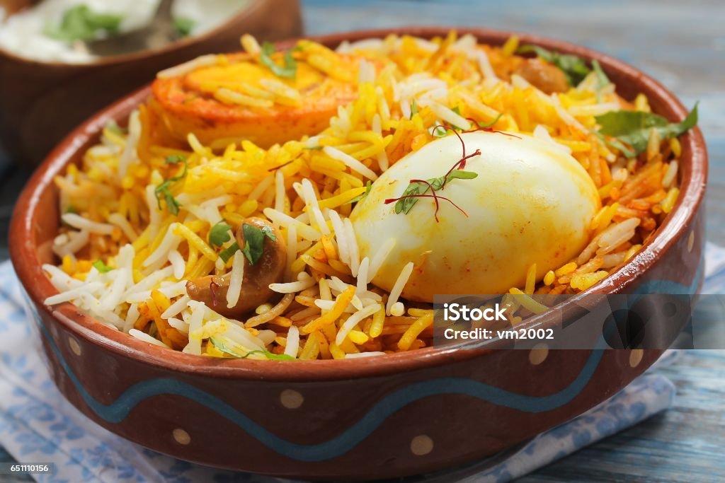 Egg Biryani served with yogurt dip on a clay pot, selective focus Egg Biryani served in a clay pot with yogurt dip, selective focus Biryani Stock Photo