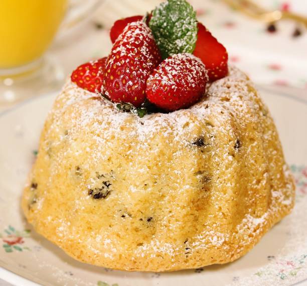 Homemade Mini Bundt Cake topped with fresh strawberries and dusted in powdered sugar, selective focus