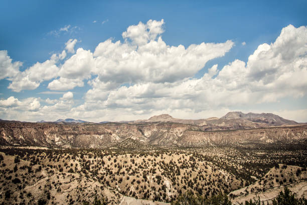 Cone-shaped tent rock formations and trees.