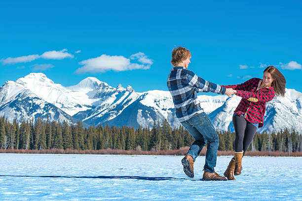 istock Young couple hold hands and swing on icy pond 651186627