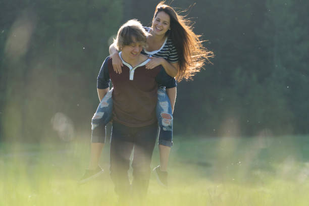 istock Young couple piggyback through mountain meadow 651186663