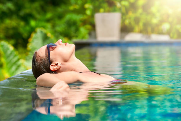 Close up view of an attractive young woman relaxing on a spa's swimming pool. stock photo