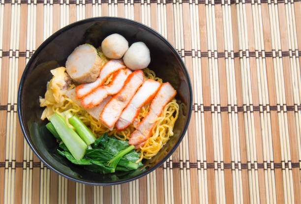 istock Egg noodle soup with red roast pork on wooden background 651205460