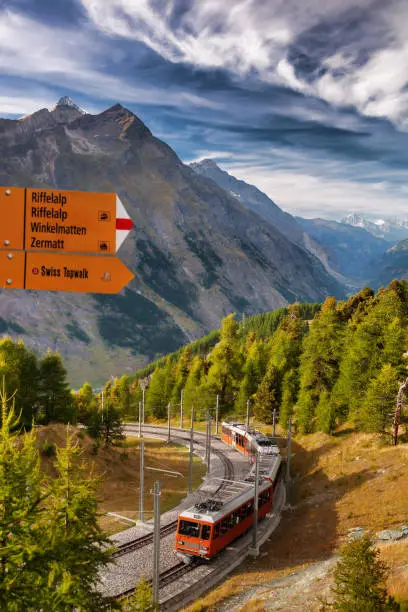 Signpost against Zermatt train in Swiss Alps