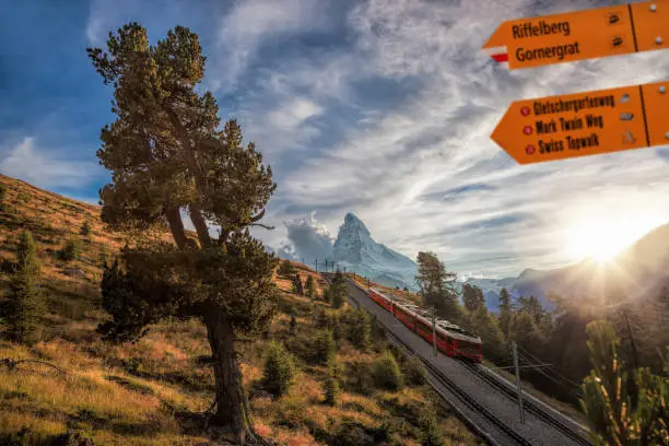 Matterhorn peak with Signpost against train in Swiss Alps