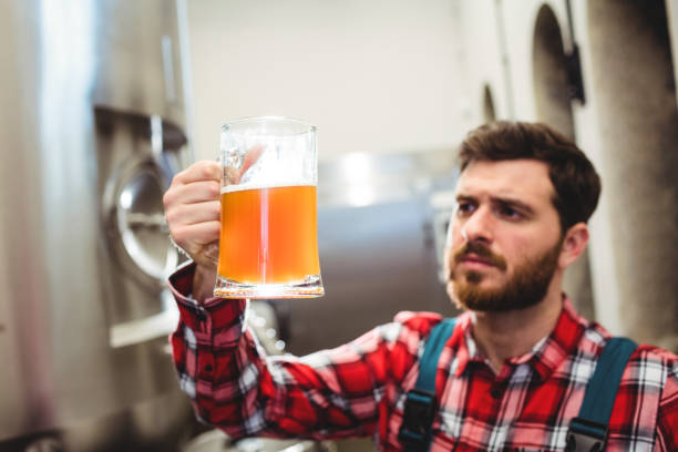 istock Manufacturer examining beer in jug at brewery 651221612