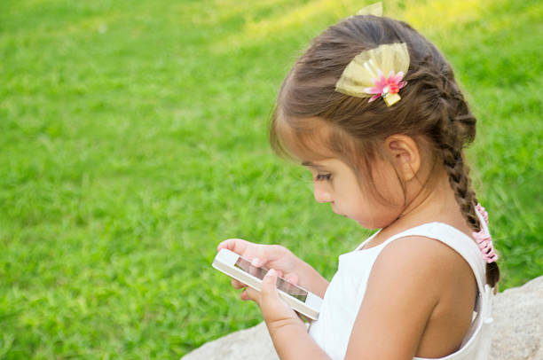 istock Beautiful little girl using mobile phone 651225972