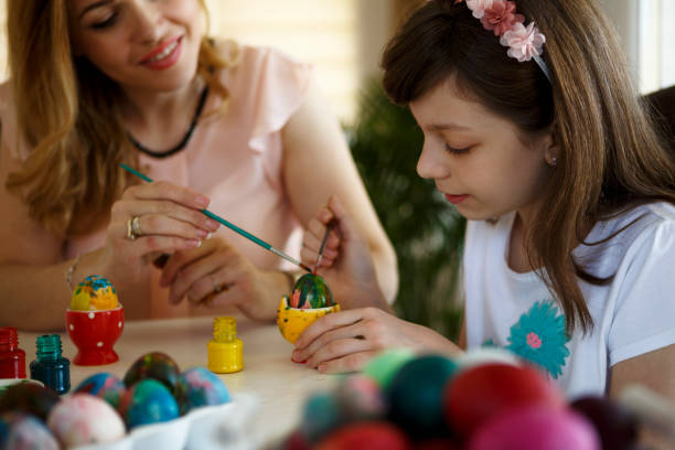 istock Mother and daughter coloring Easter eggs at home 651233004