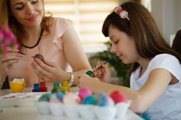 istock Mother and daughter coloring Easter eggs at home 651233172