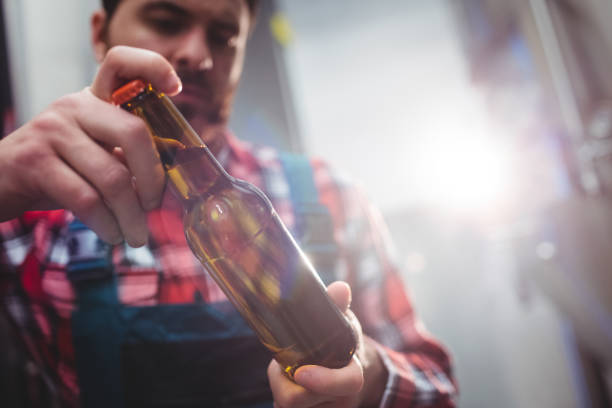 istock Male manufacturer examining beer bottle 651240326