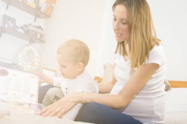 istock Pregnant mother  and her son are reading a book. 651244396