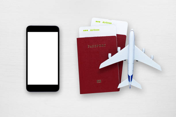 istock Smartphone, plane tickets, passports and toy plane on table 651244502
