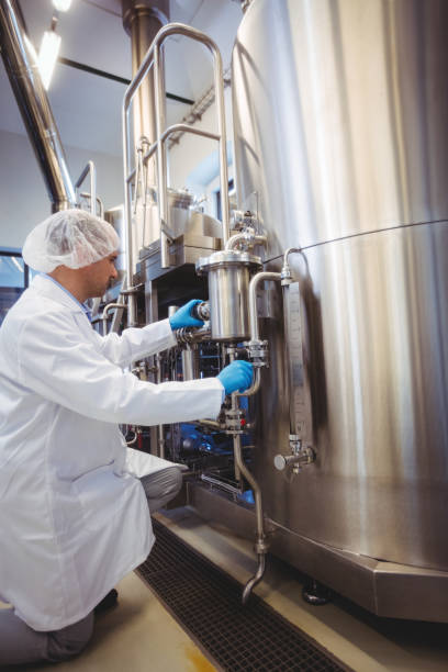 istock Manufacturer working at storage tanks in brewery 651244874