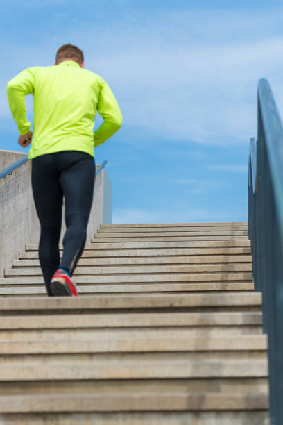 istock Athletic sport runner man running up stairs in urban training 651250922
