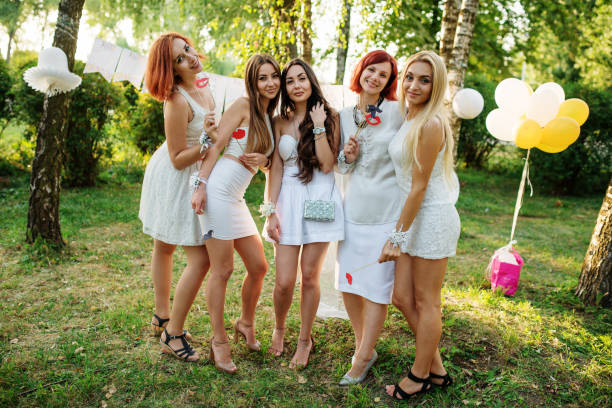 Girls wearing on white dresses having fun on hen party. Girls wearing on white dresses having fun on hen party. bachelor and bachelorette parties stock pictures, royalty-free photos & images