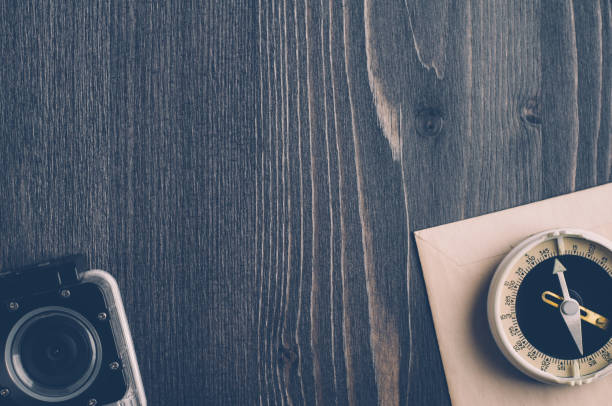 istock Old compass and camera on a dark wooden background 651327332