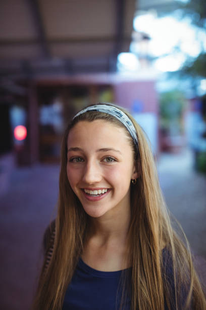 Portrait of happy schoolgirl standing in school campus