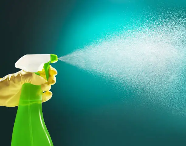 hand holding a pump detrergent bottle spraying liquid