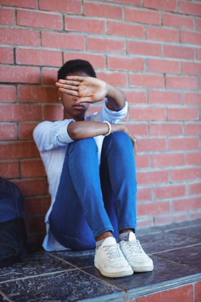 istock Sad schoolgirl covering her face with hand 651335314