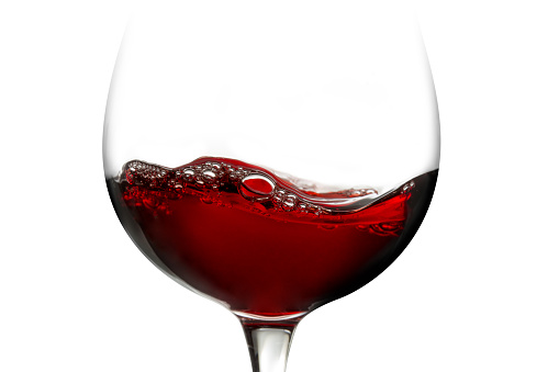 close up of red wine in a glass isolated on white background